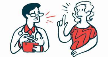 A person in a red shirt talks with a clinician in a white coat and glasses.