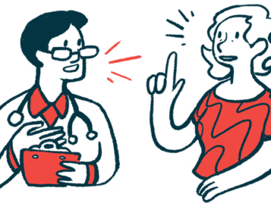 A person in a red shirt talks with a clinician in a white coat and glasses.