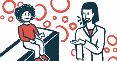 A child in a red shirt sits on an exam table and talks to a doctor in a white coat.