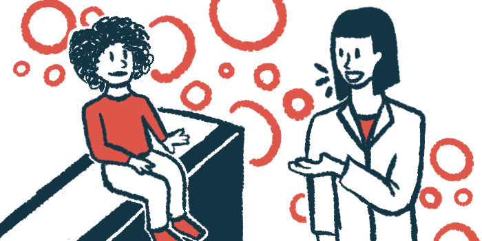 A child in a red shirt sits on an exam table and talks to a doctor in a white coat.
